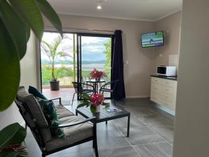 a living room with a couch and a table with flowers on it at The Frangipani Suite - One bedroom apartment in Cooktown in Cooktown
