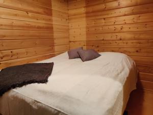 um quarto com uma cama numa parede de madeira em Topin Mestari Ruka em Ruka