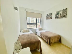Ένα ή περισσότερα κρεβάτια σε δωμάτιο στο Akira Flats Diagonal Mar Apartments