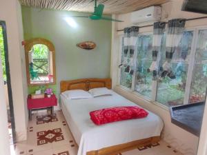 a bedroom with a bed in a room with windows at Bono Nibash Hill Resort in Bāndarban