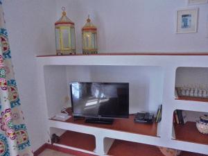 a living room with a tv on a shelf at Apartamento Neptuno in Benagil