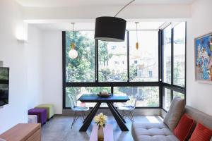 a living room with a table in front of a window at Wine Glass by HolyGuest in Tel Aviv