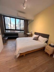 1 dormitorio con cama grande y ventana grande en 茄萣路科民宿 