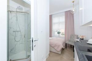 a bathroom with a shower and a bedroom at La Boutique Studio Sopot in Sopot