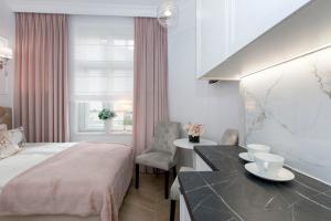 a hotel room with a bed and a desk and a window at La Boutique Studio Sopot in Sopot