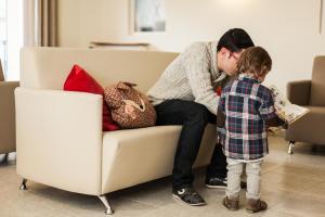 a man and a child sitting on a couch at Hotel Catalunya Ribes de Freser in Ribes de Freser