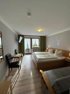 a bedroom with two beds and a desk and a chair at Gasthof Zum Ott in Staudach-Egerndach