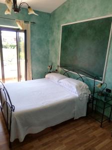 a bedroom with a bed and a green wall at Relais Maria Luisa Locazione turistica di Simona Capaccio in Fiumicino