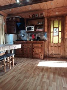 a kitchen with wooden cabinets and a table and a window at Котедж Віадук in Vorokhta