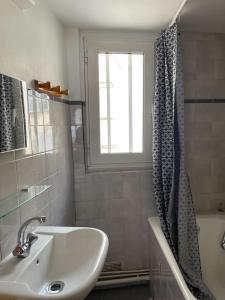 een badkamer met een wastafel en een douchegordijn bij Vavin luxembourg garden in Parijs