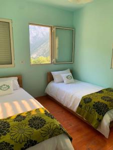 2 camas en una habitación con 2 ventanas en VITA Guesthouse, en Kolgecaj