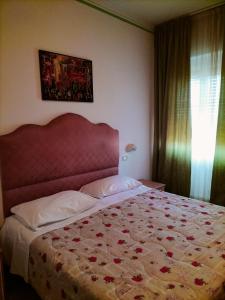 una camera con un grande letto con testiera rossa di Il Centrale a Cortona