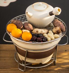 Longhushan Hanxiangju Homestay في Yingtan: غلاية شاي وفاكهة في سلة على طاولة
