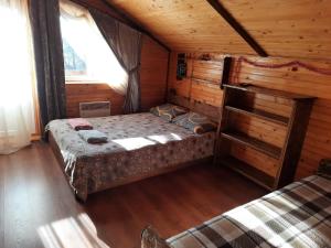 1 dormitorio con 1 cama en una cabaña de madera en Котедж Віадук, en Vorokhta