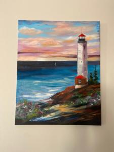 a painting of a lighthouse on a wall at Loutraki Vacation in Loutraki