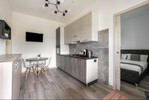 a kitchen and a bedroom with a bed and a table at Aragon Cottage Apartments in Le Castella