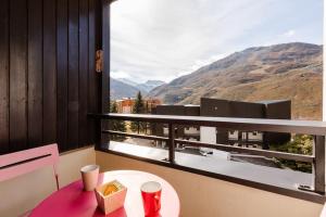 einen Balkon mit einem Tisch und Bergblick in der Unterkunft Les gentianes 311 in Les Menuires