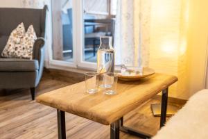 a table with two glasses and a bottle on it at Tauerncamping Apartment in Radstadt