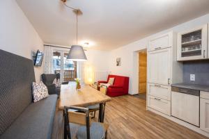 a kitchen and living room with a wooden table in a room at Tauerncamping Apartment in Radstadt