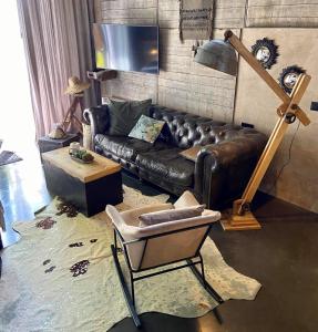 a living room with a leather couch and a table at Le Loft ATELIER in Fauvillers
