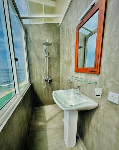 een badkamer met een wastafel en een raam bij Funky Hotel in Hikkaduwa