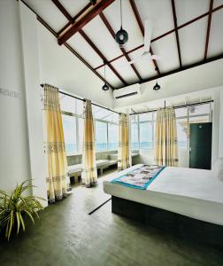 een slaapkamer met een groot bed en ramen bij Funky Hotel in Hikkaduwa