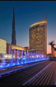 a large building with blue lights in front of it at Emaar Fashion avenue-Formerly The Address Dubai Mall residence - Downtown by Suitestay Homes in Dubai