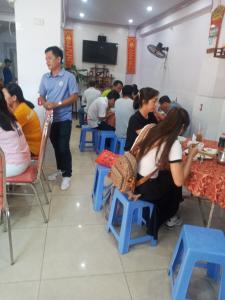 eine Gruppe von Personen, die in einem Restaurant an Tischen sitzen in der Unterkunft Khách Sạn Tú Anh in Hà Tiên