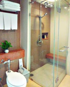 a bathroom with a glass shower with a toilet at Long Beach Cha-Am Hotel in Cha Am