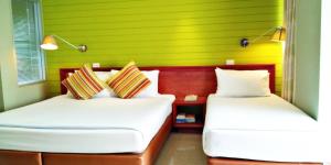 two beds in a room with a green wall at Long Beach Cha-Am Hotel in Cha Am