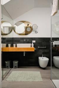 bagno con lavandino e 2 specchi di Cozy Studio Downtown a Bassano del Grappa