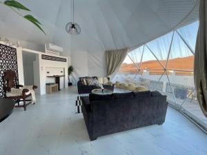 a living room with two couches and a large window at شاليه الروح AlRooh Chalet in Al Raka