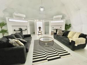 a living room with two couches and a table at شاليه الروح AlRooh Chalet in Al Raka