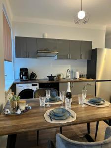 EVIS LTD apartments 3 في ريزكني: مطبخ مع طاولة خشبية مع لوحات واكواب للنبيذ
