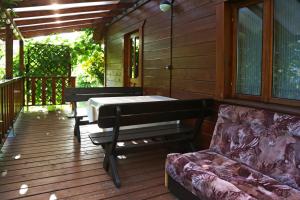 a porch with a piano and a couch on a deck at Smolniki 28 in Smolniki