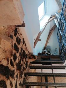 a staircase in a building with a stone wall at Gîte des Lilas 