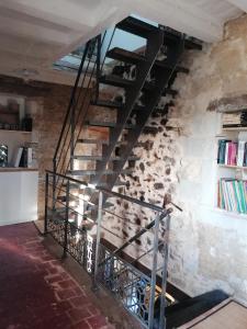 un escalier métallique en colimaçon dans un mur de briques dans l'établissement Gîte des Lilas, 