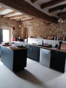 eine Küche mit schwarzen und weißen Geräten in einem Zimmer in der Unterkunft Gîte des Lilas 