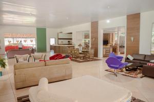 uma ampla sala de estar com sofás e cadeiras em Casa de Campo com Piscina e lazer em Cascavel PR em Cascavel