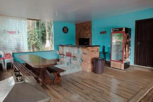 a room with a fireplace and a table and a refrigerator at Casa de Campo com Piscina e lazer em Cascavel PR in Cascavel