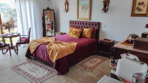 a bedroom with a bed with a purple bedspread at Quinta dos Padrinhos - Suites in the Heart of the Douro in Lamego