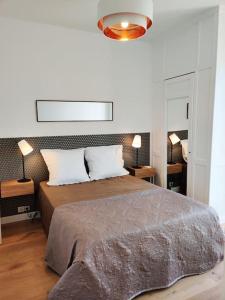 a bedroom with a large bed with two pillows at Top floor nest, balcony close to sea and old-town in Nice