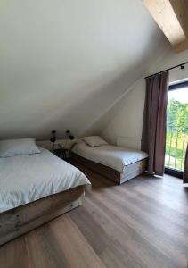 a bedroom with two beds and a large window at Weißbriach Lodge in Weissbriach