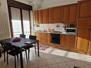 una cocina con armarios de madera y una mesa con sillas. en Iris, en Cislago