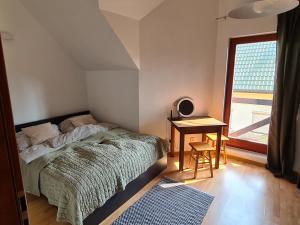 盧克的住宿－Domek nad morzem Deli，一间卧室配有一张床、一张桌子和一个窗户。