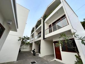 a white house with a motorcycle parked in front of it at EL Suites Canggu in Canggu