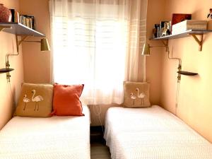 twee bedden in een kleine kamer met een raam bij Casa Nuez Moscada in Villamartin +28 foto's