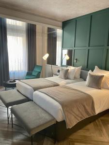 a hotel room with two beds and a chair at The Embassy Valletta Hotel in Valletta