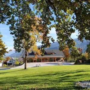 un edificio en un parque con un árbol en el primer plano en Weißbriach Lodge, en Weissbriach