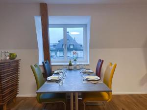 a dining room table with chairs and a large window at Schlossappartement Rapperswil in Rapperswil-Jona